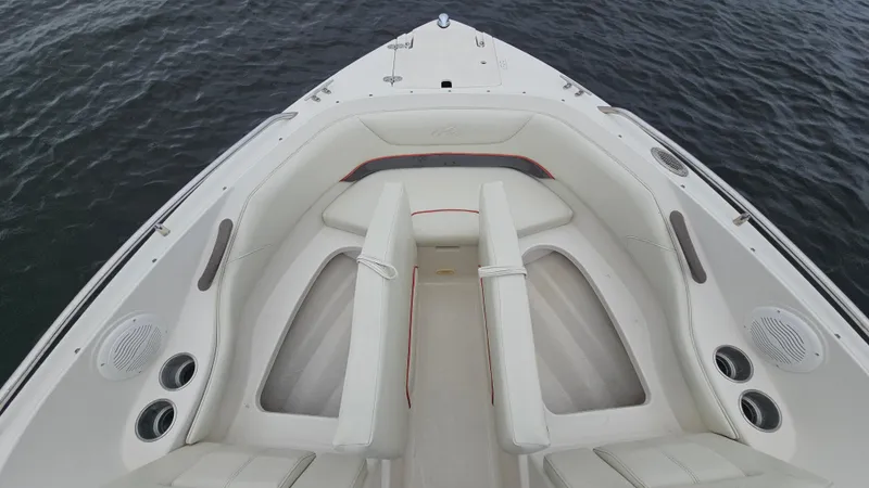 Slide: The Image of 2007 Monterey 214FS Montura boat interior with white seating and cup holders on calm water. - 40