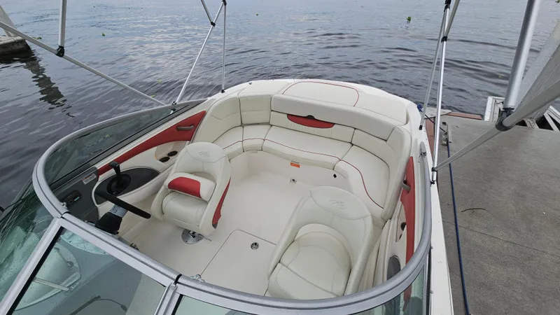 Slide: The Image of 2007 Monterey 214FS Montura boat interior with white and red seating, docked by the water. - 44