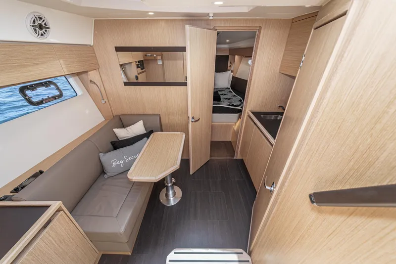 Slide: The Image of 2023 Bavaria SR36 yacht interior with modern wood finish, seating area, and kitchenette. - 41