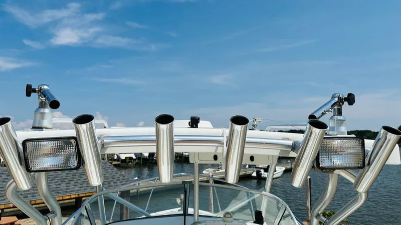 Slide: The Image of 2008 Polar 2300 Walkaround boat with rod holders and lights, docked under a clear sky. - 11