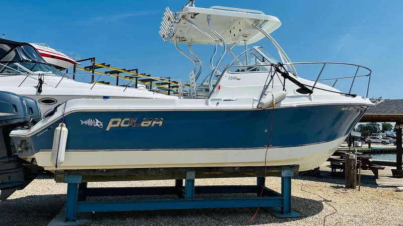 Slide: The Image of 2008 Polar 2300 Walkaround boat on display, blue and white, docked outdoors. - 3