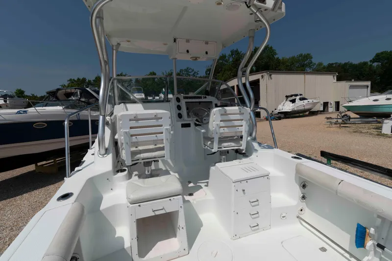 Slide: The Image of 2008 Polar 2300 Walkaround boat interior with seating and storage, docked outdoors. - 6