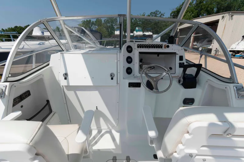 Slide: The Image of 2008 Polar 2300 Walkaround boat cockpit with steering wheel and controls, docked outdoors. - 8