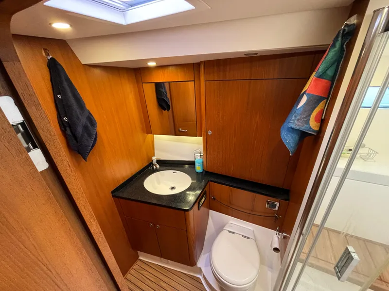 Slide: The Image of Luxurious 2014 Southerly 535 yacht bathroom with wood finish, sink, and toilet. - 22