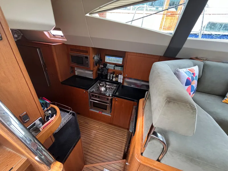 Slide: The Image of Interior of 2014 Southerly 535 yacht featuring a compact kitchen and cozy seating area. - 29