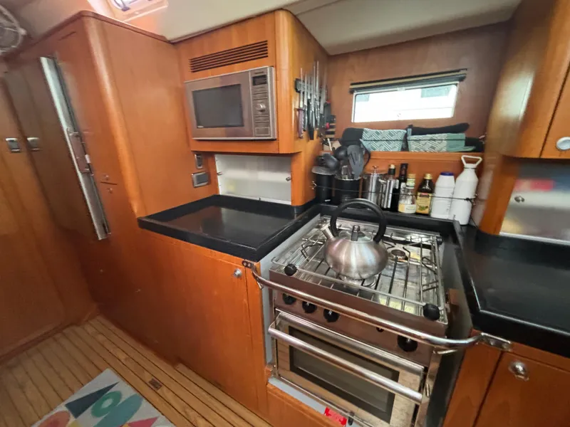 Slide: The Image of Cozy kitchen in 2014 Southerly 535 yacht with stove, microwave, and utensils. - 32