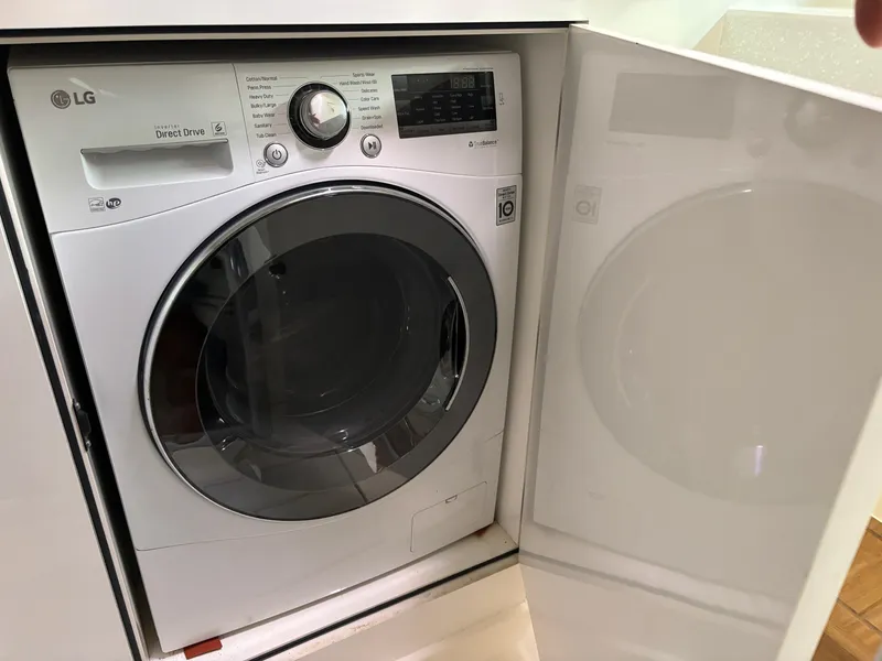 Slide: The Image of LG front-loading washing machine in a white cabinet, showcasing modern design and digital controls. - 43