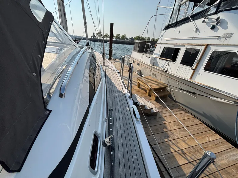 Slide: The Image of Southerly 535 yacht docked beside another boat, showcasing sleek design and wooden deck. - 49