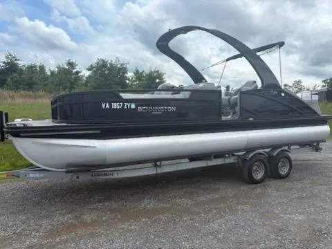 Slide: The Image of 2020 Bennington 24RTSBA pontoon boat on trailer, parked outdoors under cloudy sky. - 22