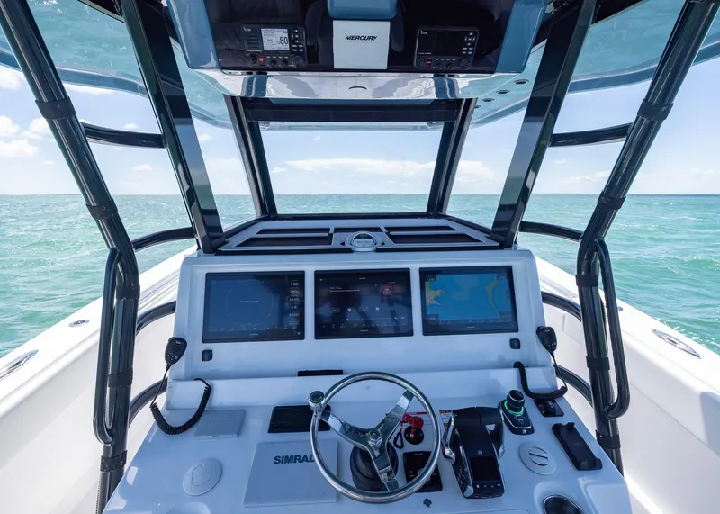 Slide: The Image of 2025 Invincible 43 Open Fisherman helm with advanced navigation systems on open sea. - 16