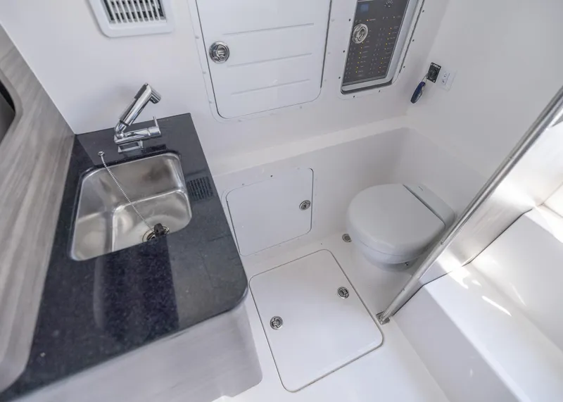 Slide: The Image of 2025 Invincible 43 Open Fisherman boat bathroom with sink, toilet, and control panel. - 30