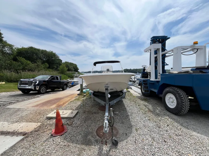 Slide: The Image of 2013 Carolina Skiff 178 DLV boat on trailer, parked near truck and equipment. - 1