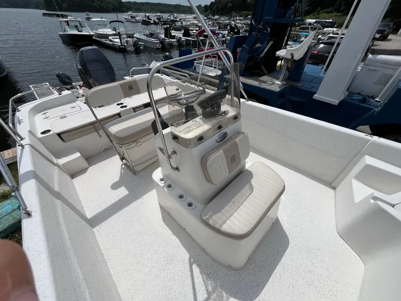 Slide: The Image of 2013 Carolina Skiff 178 DLV boat interior with seating and control console at marina. - 12