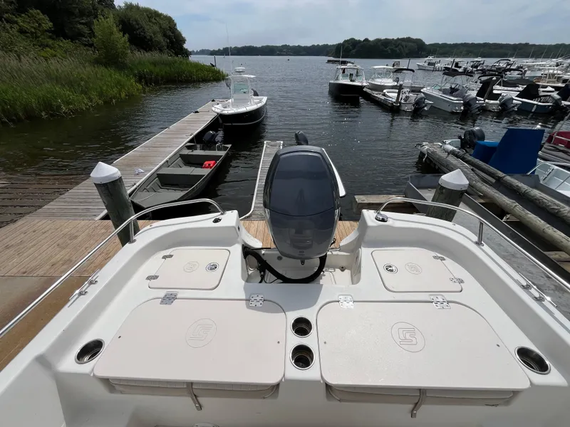 Slide: The Image of 2013 Carolina Skiff 178 DLV boat docked at a marina with scenic water view. - 15