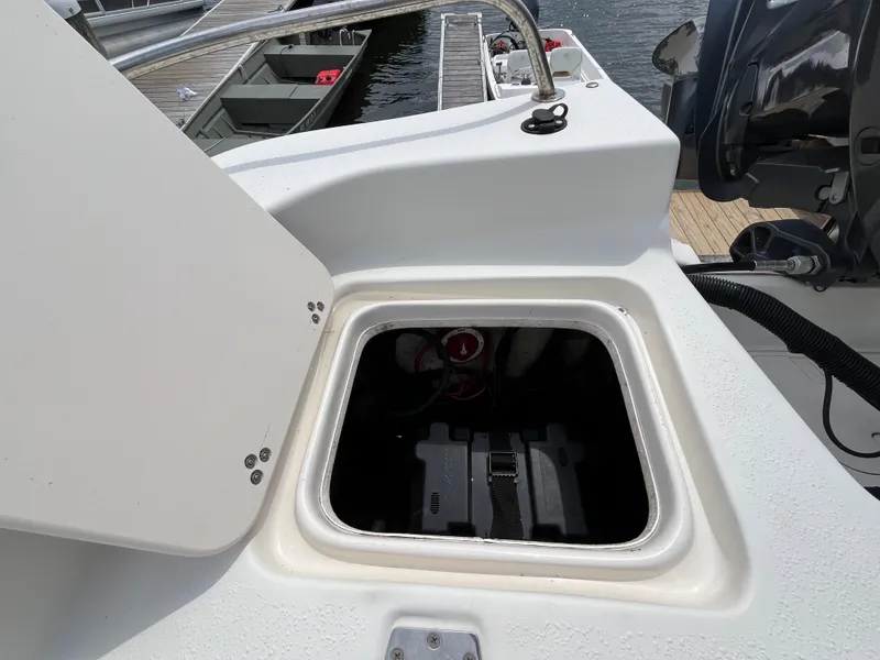 Slide: The Image of 2013 Carolina Skiff 178 DLV boat battery compartment open at dock. - 18