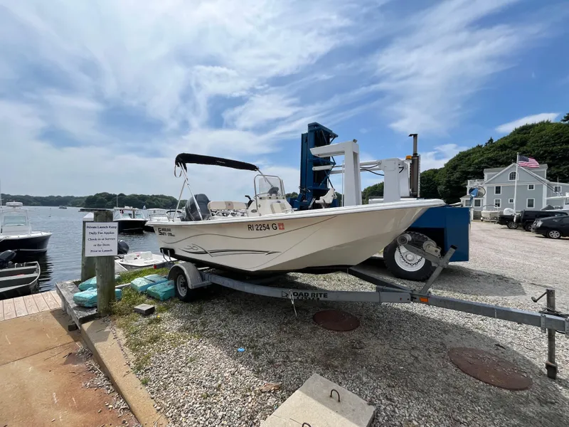 Slide: The Image of 2013 Carolina Skiff 178 DLV boat on trailer by waterfront, under blue sky. - 2