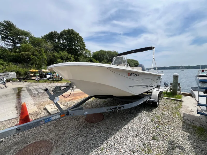Slide: The Image of 2013 Carolina Skiff 178 DLV boat on trailer by lakeside, under clear sky. - 8