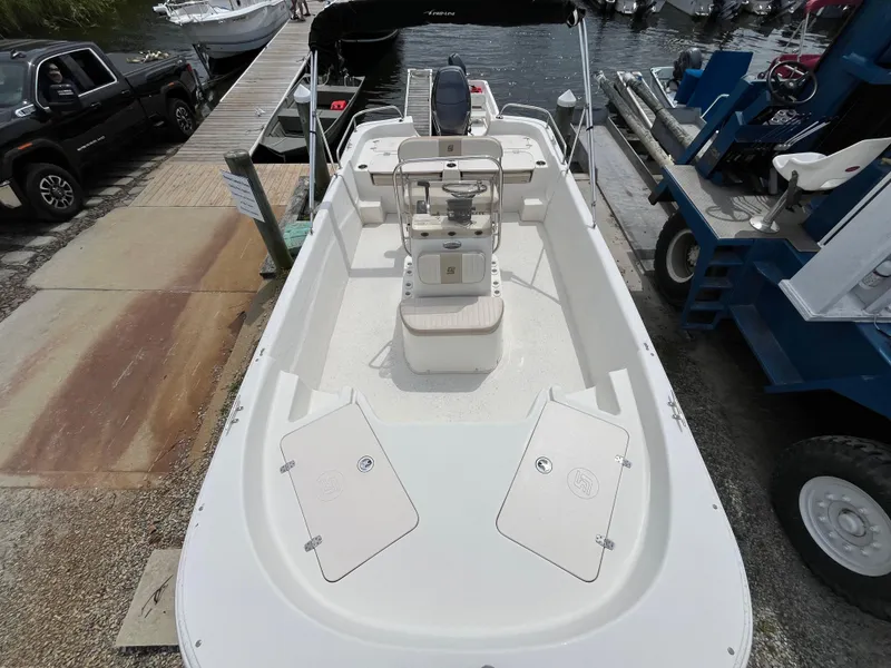 Slide: The Image of 2013 Carolina Skiff 178 DLV boat docked, featuring spacious deck and seating. - 9