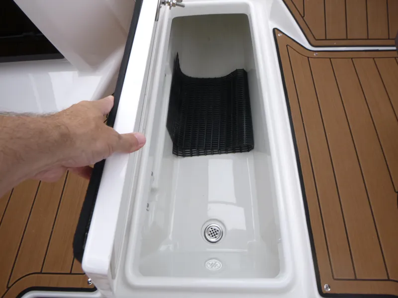 Slide: The Image of Open storage compartment on 2025 Yamaha Boats 275 SD, featuring teak-style flooring. - 13