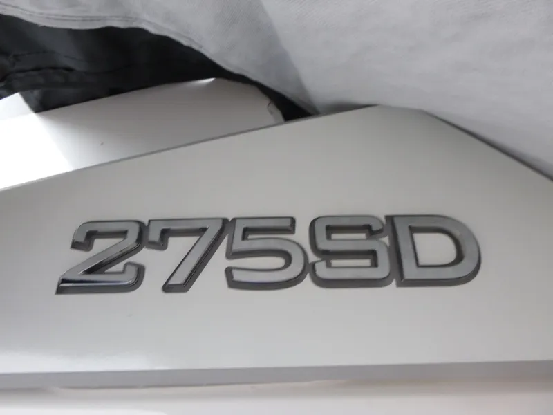 Slide: The Image of Close-up of 2025 Yamaha Boats 275 SD model emblem on white surface. - 18