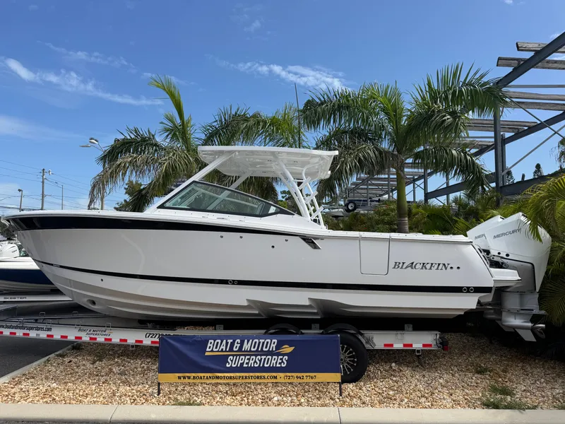 The Image of 2026 Blackfin 302 DC boat displayed at dealership, surrounded by palm trees. - 1
