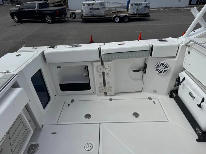 Slide: The Image of 2026 Blackfin 302 DC boat deck with storage compartments and seating area. - 12