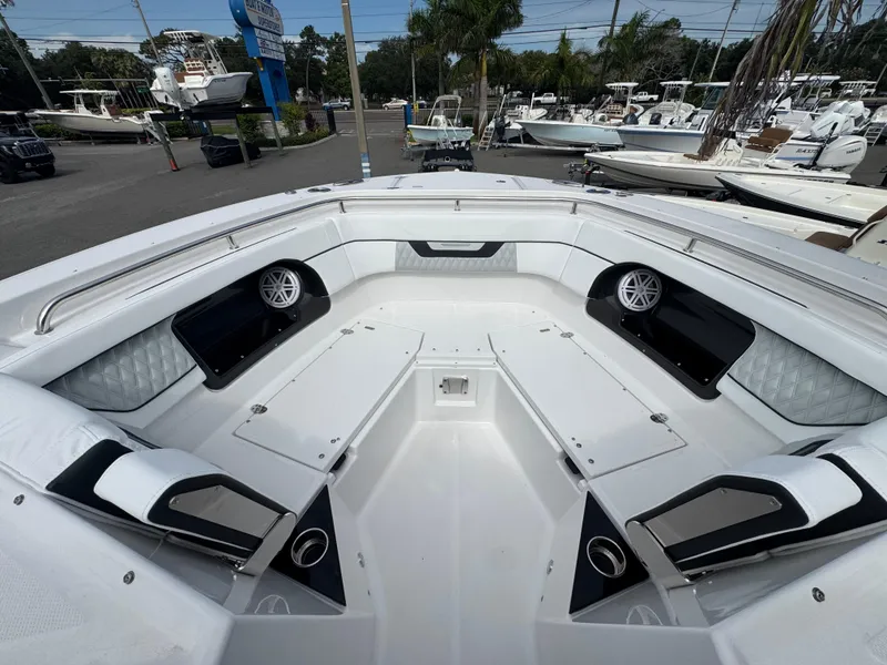Slide: The Image of 2026 Blackfin 302 DC boat interior with seating and speakers, displayed at a marina. - 25