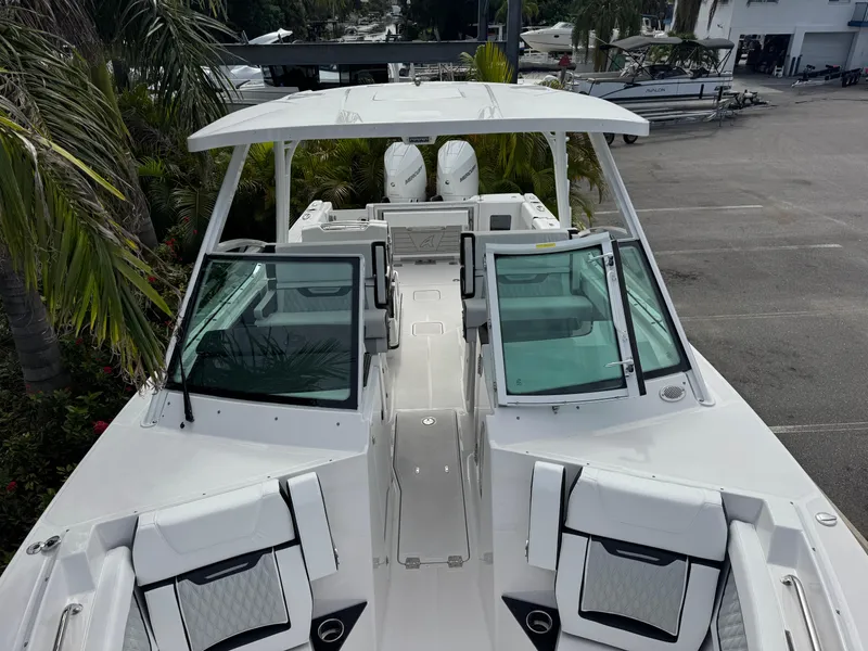 Slide: The Image of 2026 Blackfin 302 DC boat with open deck and seating, parked near palm trees. - 29
