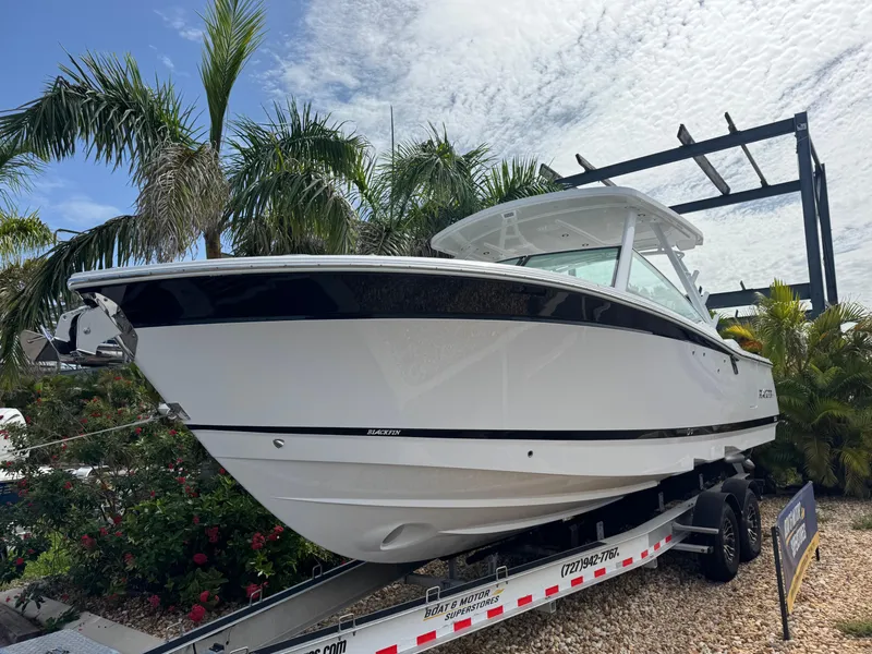 Slide: The Image of 2026 Blackfin 302 DC boat on trailer, surrounded by palm trees and a cloudy sky. - 3