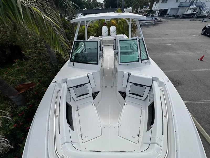 Slide: The Image of 2026 Blackfin 302 DC boat with spacious seating and sleek design, docked near palm trees. - 30