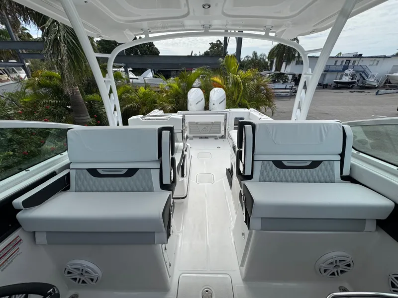 Slide: The Image of 2026 Blackfin 302 DC boat interior with modern seating and dual engines, surrounded by lush greenery. - 32
