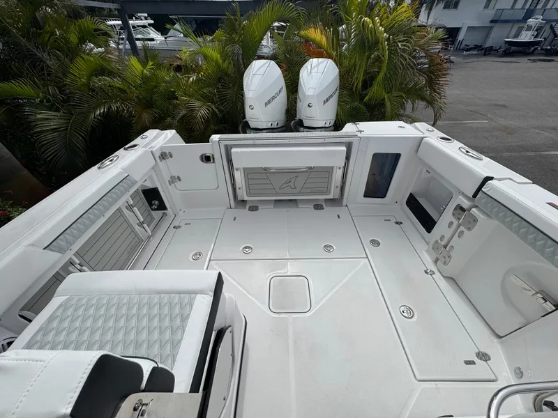 Slide: The Image of 2026 Blackfin 302 DC boat deck with dual Mercury engines, surrounded by lush greenery. - 36