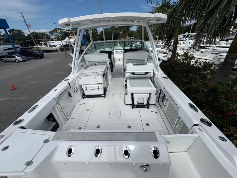 Slide: The Image of 2026 Blackfin 302 DC boat interior with seating and storage, docked near palm trees. - 7