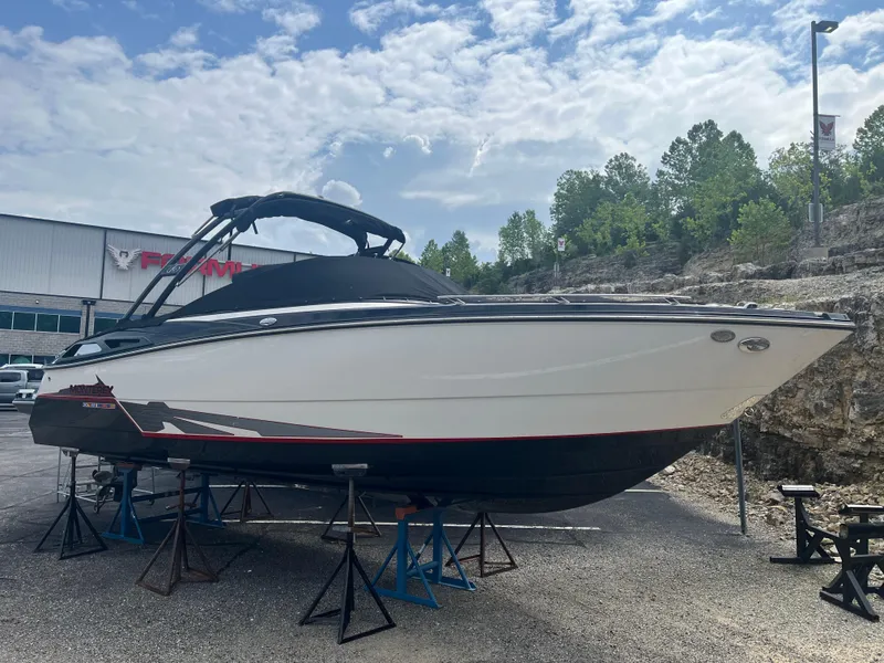 The Image of 2014 Monterey 268SS Bowrider boat on stands, outdoor display, cloudy sky background. - 1