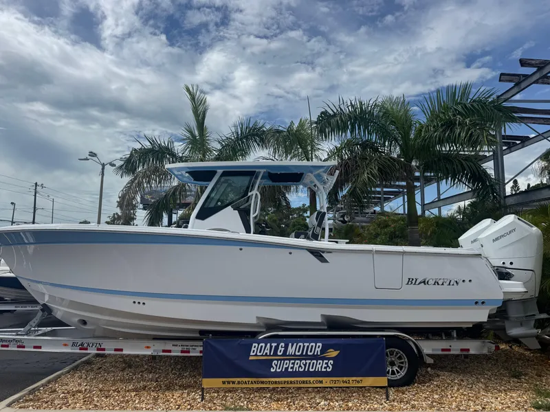 The Image of 2026 Blackfin 302 CC boat displayed at dealership, surrounded by palm trees. - 1