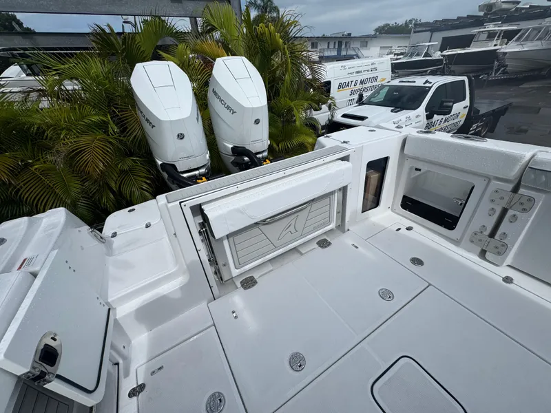 Slide: The Image of 2026 Blackfin 302 CC boat with dual Mercury outboard engines, docked near palm trees. - 17