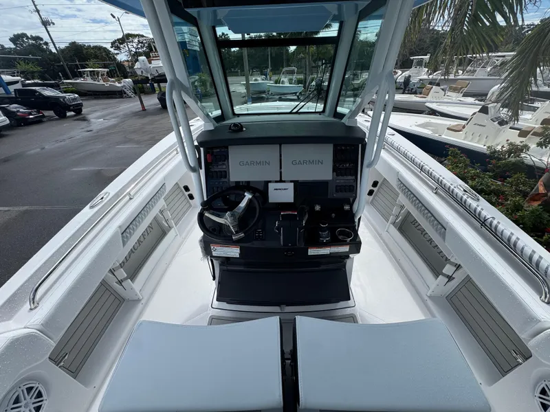 Slide: The Image of 2026 Blackfin 302 CC boat cockpit with Garmin navigation system and steering wheel. - 22