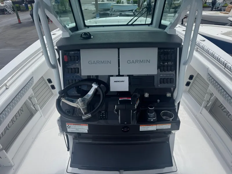Slide: The Image of 2026 Blackfin 302 CC boat dashboard with Garmin displays and Mercury controls. - 23