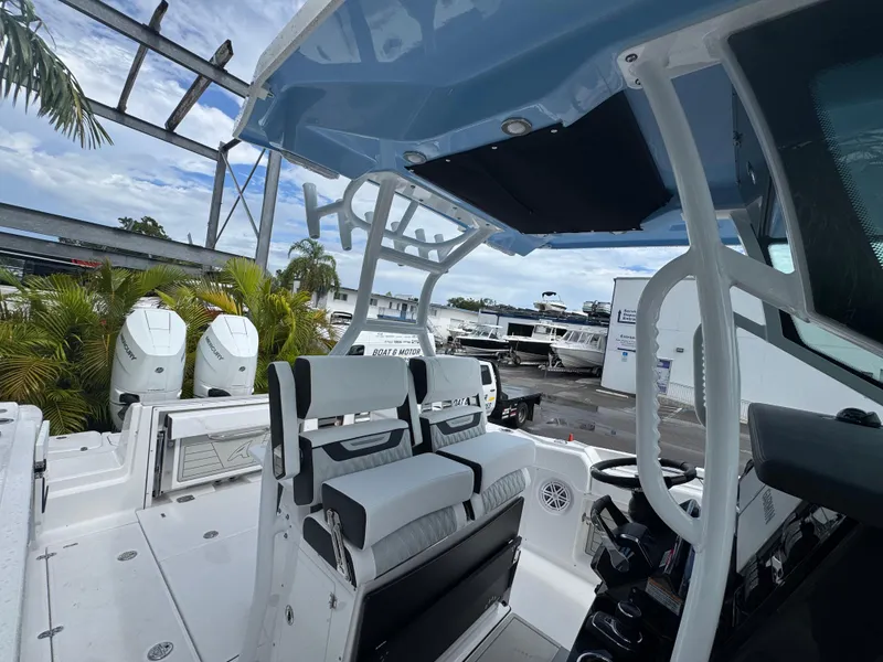 Slide: The Image of 2026 Blackfin 302 CC boat interior with dual Mercury engines, docked near palm trees. - 37