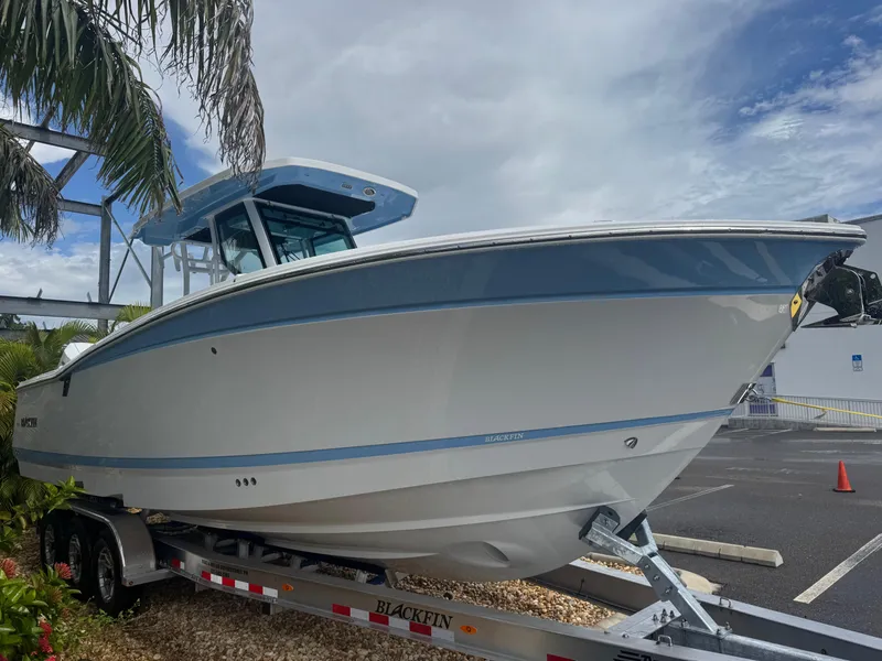 Slide: The Image of 2026 Blackfin 302 CC boat on trailer, parked outdoors under cloudy sky. - 4
