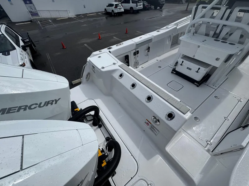 Slide: The Image of 2026 Blackfin 302 CC boat deck with Mercury engines, wet surface, and seating area. - 8