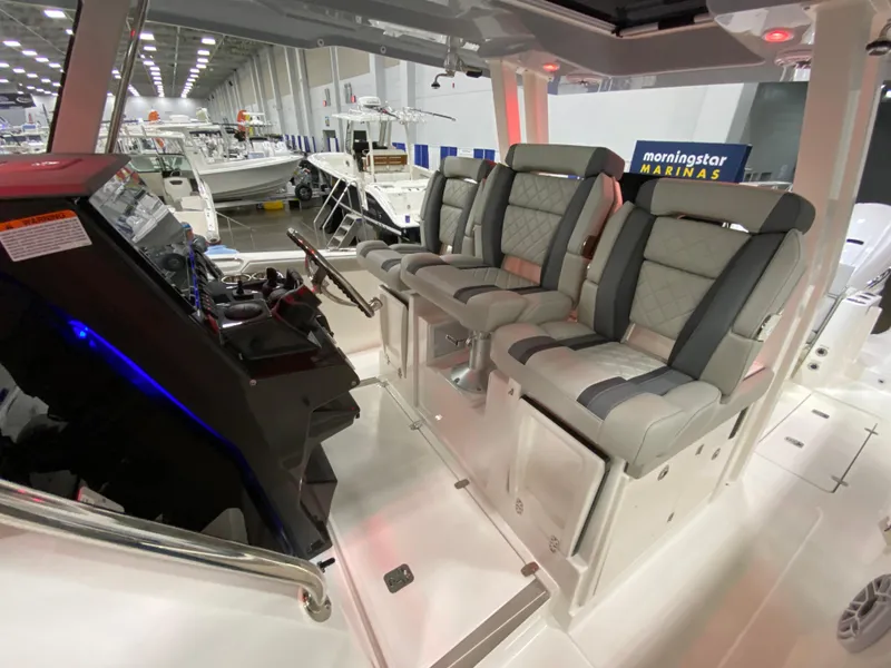 Slide: The Image of 2024 Pursuit S 358 boat interior with luxurious seating at a marina exhibition. - 17
