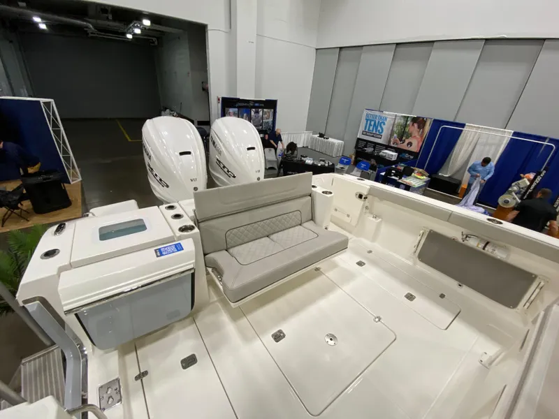 Slide: The Image of 2024 Pursuit S 358 boat interior with dual engines and seating at a boat show. - 8