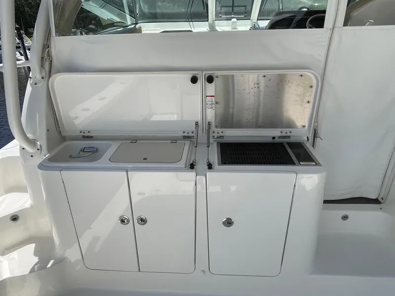 Slide: The Image of 2021 Pursuit OS 385 Offshore boat galley with sink and storage compartments. - 15