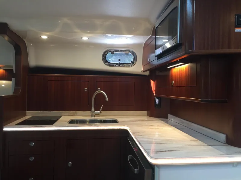 Slide: The Image of Luxurious 2021 Pursuit OS 385 Offshore yacht kitchen with wood cabinetry and modern appliances. - 22