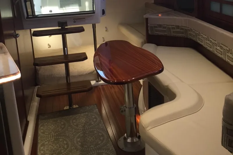 Slide: The Image of 2021 Pursuit OS 385 Offshore cabin interior with wooden table and seating. - 23