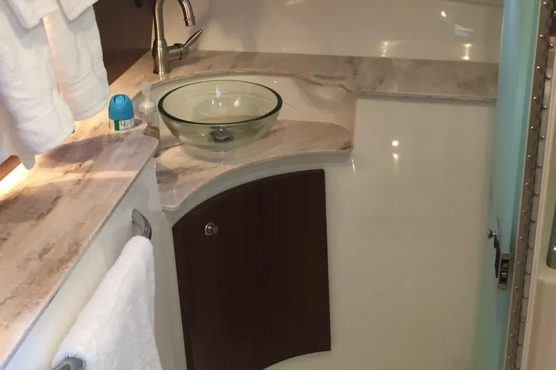 Slide: The Image of 2021 Pursuit OS 385 Offshore bathroom with glass sink and marble countertop. - 24