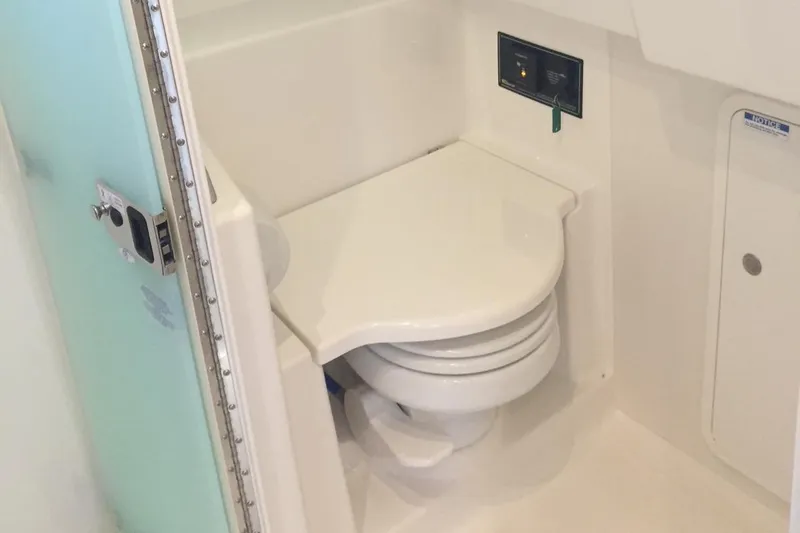 Slide: The Image of 2021 Pursuit OS 385 Offshore boat bathroom with compact toilet and control panel. - 25