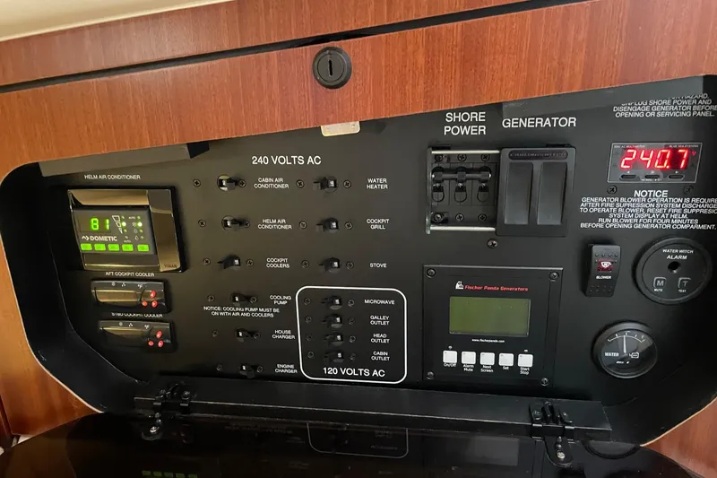 Slide: The Image of Electrical control panel of 2021 Pursuit OS 385 Offshore boat, featuring various switches and displays. - 26