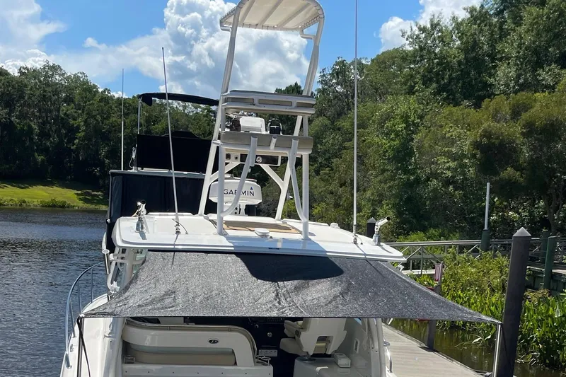 Slide: The Image of 2021 Pursuit OS 385 Offshore boat docked by a scenic riverbank. - 7